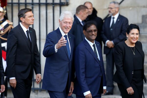 Бывший президент США Билл Клинтон прибывает в церковь Сен-Сюльпис на церемонию прощания с бывшим президентом Франции Жаком Шираком - Sputnik Таджикистан