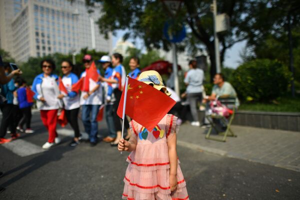 Девочка с китайским флагом на военном параде в честь 70-летия образования КНР в Пекине - Sputnik Таджикистан