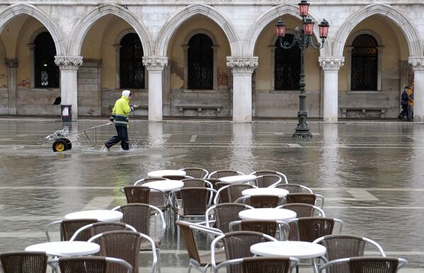 Итальянский почтальон пересекает затопленную площадь Сан-Марко в Венеции - Sputnik Таджикистан