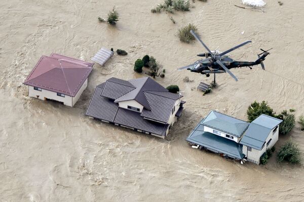 Вертолет над жилыми районами, затопленными рекой Чикума после тайфуна Хагибис в Нагано, центральная Япония - Sputnik Таджикистан