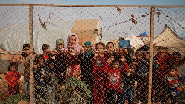 Сирийские дети у забора палаточного лагеря недалеко от деревни Кафр-Лусин, Сирия - Sputnik Тоҷикистон