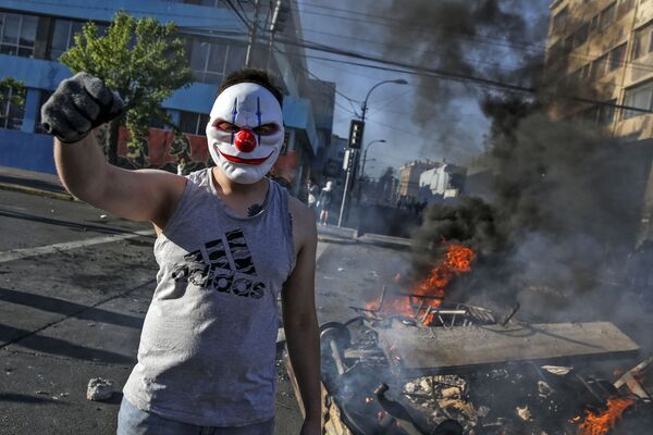 Демонстрант в маске во время протестов в Сантьяго, Чили - Sputnik Таджикистан