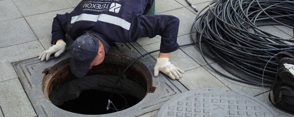 Рабочий прокладывает кабель в Москве. - Sputnik Тоҷикистон