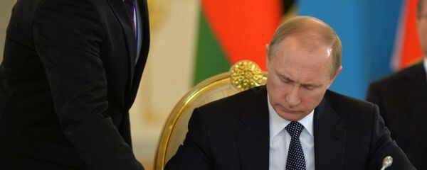 Президент РФ Владимир Путин подписывает документ, архивное фото - Sputnik Тоҷикистон