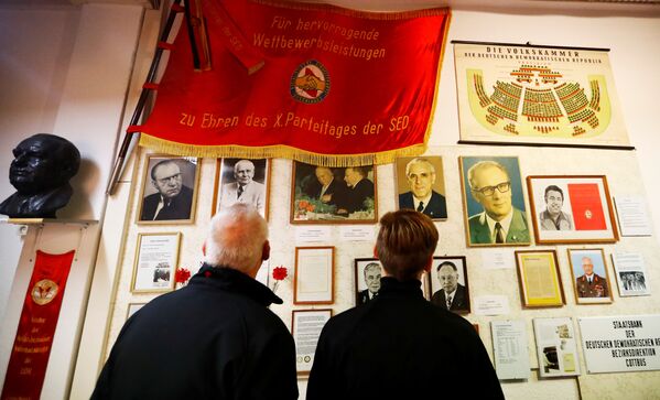 Посетители в музее ГРД в Пирне рассматривают портреты политиков, документы и знамя - Sputnik Таджикистан