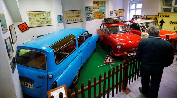 Посетитель в музее рассматривает автомобили и дорожные знаки ГДР - Sputnik Таджикистан