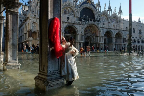 Туристка фотографируется на площади Сан-Марко во время наводнения в Венеции - Sputnik Таджикистан