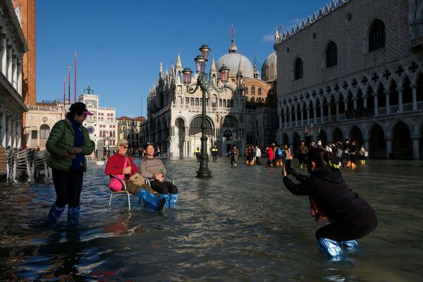 Туристы фотографируются на площади Сан-Марко во время наводнения в Венеции - Sputnik Таджикистан