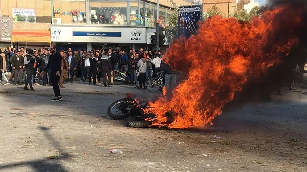 Горящий мотоцикл во время протестов в Иране 