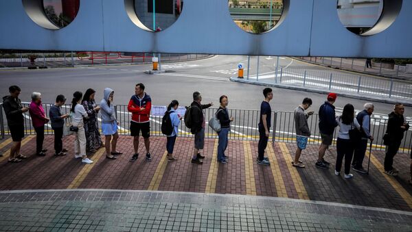 Люди стоят в очереди, чтобы отдать свой голос во время выборов в районный совет в округе Нг Кван О в Гонконге - Sputnik Таджикистан