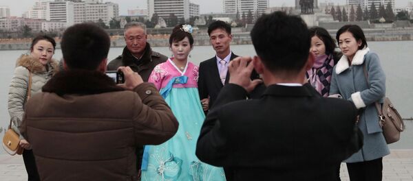Молодожены во время свадебной фотосессии со своими родственниками в Пхеньяне - Sputnik Таджикистан