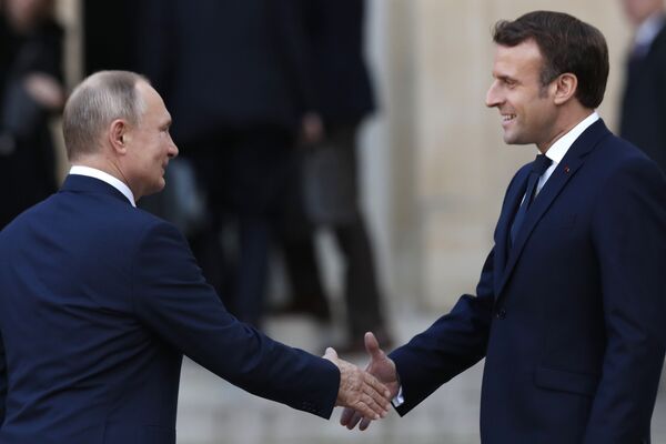 Президент Эммануэль Макрон (справа) и президент России Владимир Путин приветствуют друг друга в Елисейском дворце в понедельник, 9 декабря 2019 года в Париже - Sputnik Таджикистан