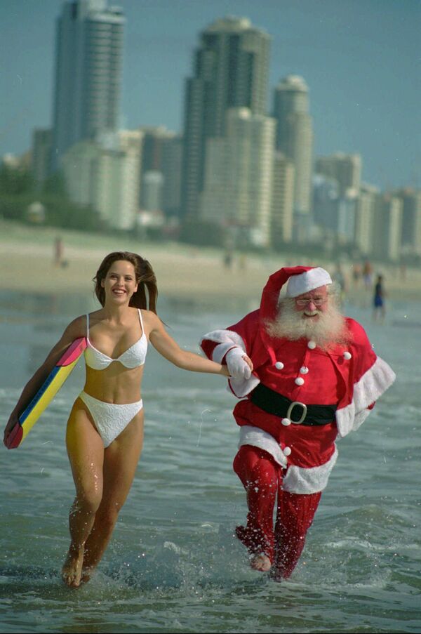 20-летняя австралийка и Санта-Клаус на пляже Серферс-Парадайз в Квинсленде, Австралия - Sputnik Таджикистан