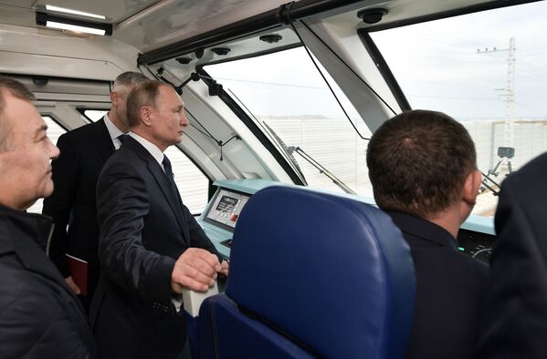 Президент России Владимир Путин в кабине машиниста рельсового автобуса, который отправляется в первый рейс по железной дороге Крымского моста - Sputnik Таджикистан