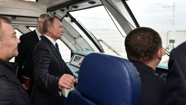 Президент России Владимир Путин в кабине машиниста рельсового автобуса, который отправляется в первый рейс по железной дороге Крымского моста - Sputnik Таджикистан
