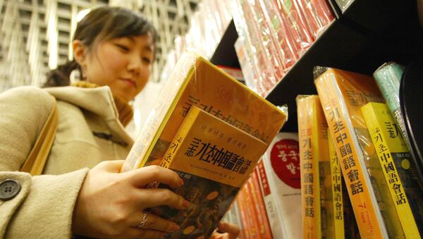 Студентка держит книги на китайском языке, архивное фото - Sputnik Таджикистан