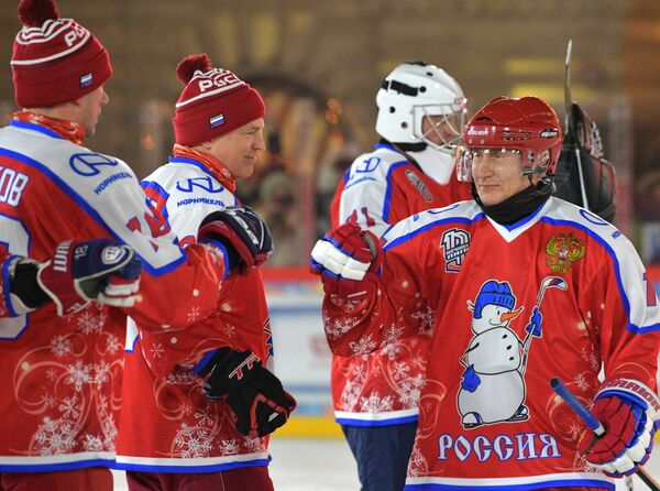 Президент России Владимир Путин приветствует игроков перед началом предновогоднего товарищеского матча Ночной хоккейной лиги на катке на Красной площади - Sputnik Таджикистан