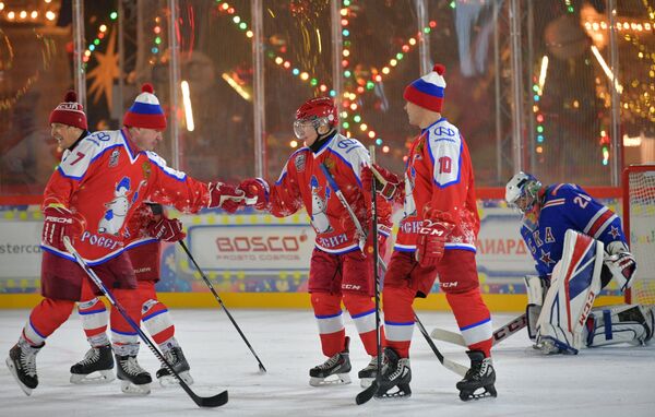 Президент России Владимир Путин радуется заброшенной шайбе в предновогоднем товарищеском матче Ночной хоккейной лиги на катке на Красной площади - Sputnik Таджикистан