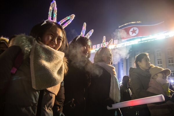Девушки смотрят запуск салюта во время празднования Нового года в КНДР  - Sputnik Таджикистан