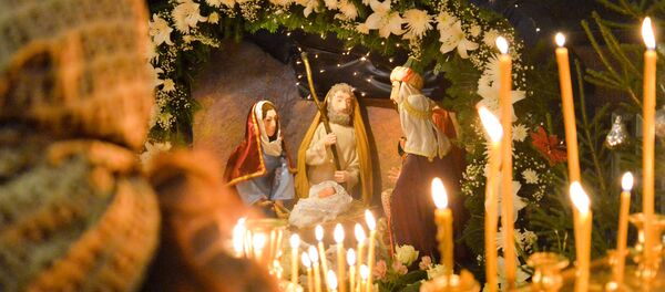 Женщина возле Рождественского вертепа - Sputnik Таджикистан
