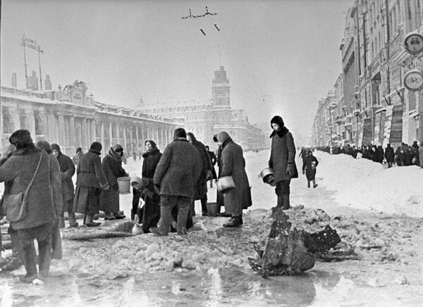Жители блокадного Ленинграда набирают воду, появившуюся после артобстрела в пробоинах в асфальте - Sputnik Таджикистан