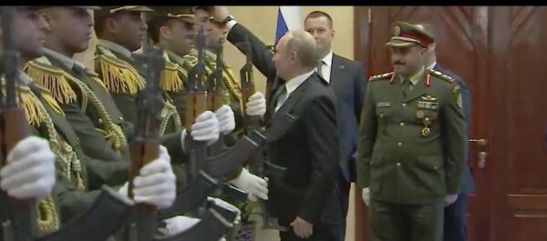 Владимир Путин сарпӯши афсари қаравулро аз замин бардошта ба сараш пӯшонд - Sputnik Тоҷикистон