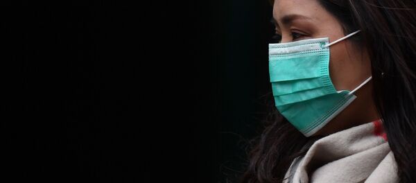 Девушка в медицинской маске в районе Чайна-таун в Лондоне Девушка в медицинской маске в районе Чайна-таун в Лондоне - Sputnik Таджикистан