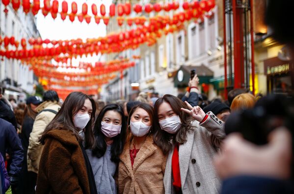 Люди в медицинских масках во время празднования Китайского нового года в районе Чайна-таун в Лондоне - Sputnik Тоҷикистон
