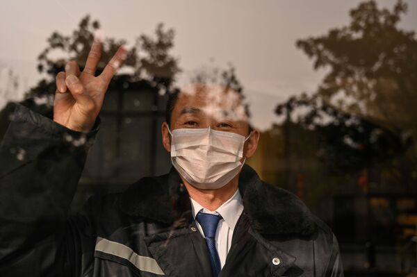 Охранник отеля в маске в китайском городе Ухань  - Sputnik Тоҷикистон