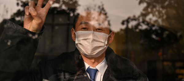 Охранник отеля в маске в китайском городе Ухань  - Sputnik Таджикистан