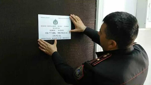 Таджикские милиционеры приклеивают информационные плакаты - Sputnik Тоҷикистон