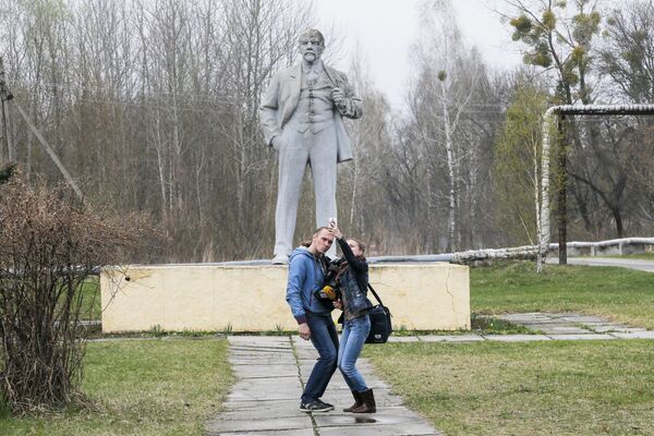 Журналисты делают селфи на фоне памятника Ленину в Чернобыле - Sputnik Таджикистан