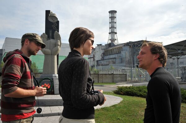 Туристы из Бельгии перед саркофагом, возведенным над разрушенным 4-м энергоблоком Чернобыльской АЭС - Sputnik Таджикистан