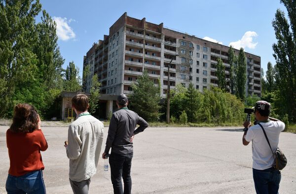 Туристы во время экскурсии в зону отчуждения Чернобыльской атомной электростанции имени Владимира Ильича Ленина в городе Припяти - Sputnik Таджикистан