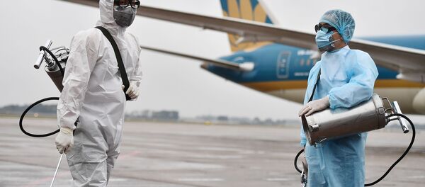 Сотрудники в защитных костюмах готовятся к дезинфекции самолета - Sputnik Таджикистан