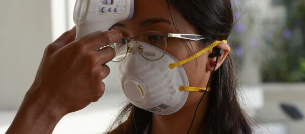 Студентке в защитной маске измеряют температуру Студентке в защитной маске измеряют температуру - Sputnik Таджикистан