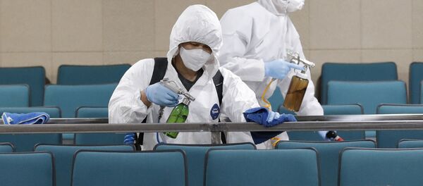 Рабочие в защитных костюмах распыляют дезинфицирующее средство - Sputnik Тоҷикистон