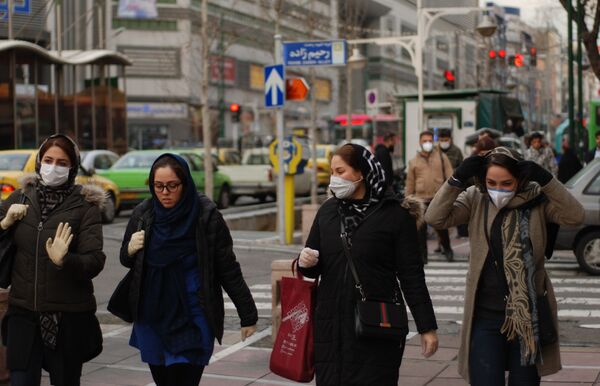 Жители Тегерана в медицинских масках на одной из улиц города - Sputnik Тоҷикистон
