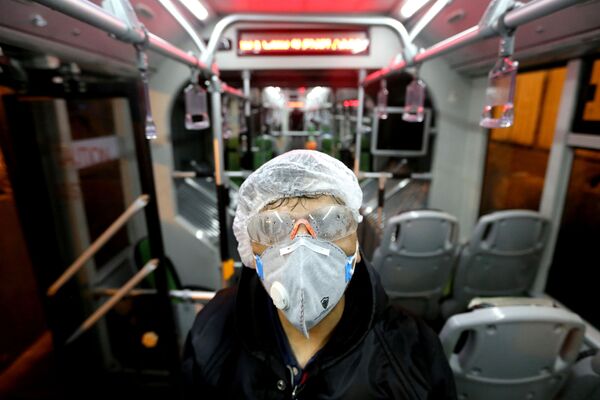 Сотрудник муниципалитета Тегерана дезинфицирует  автобус, чтобы избежать распространения коронавируса - Sputnik Тоҷикистон