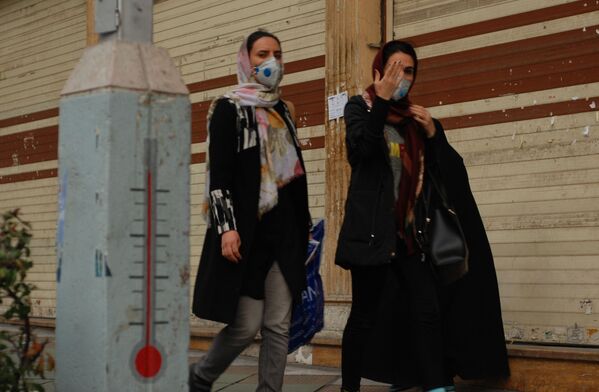Жители Тегерана идут по одной из центральных улиц в медицинских масках - Sputnik Тоҷикистон