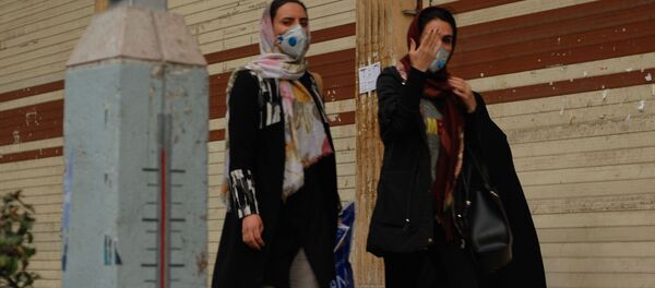 Жители Тегерана идут по одной из центральных улиц в медицинских масках - Sputnik Тоҷикистон