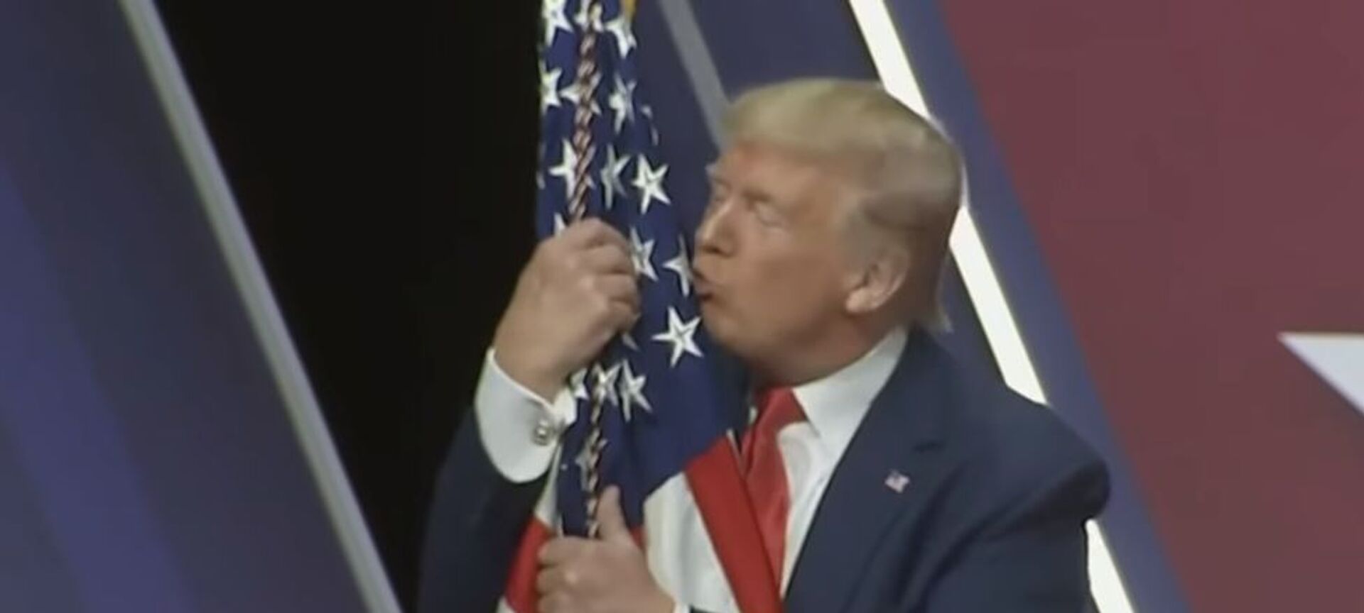 А он его целует: Дональд Трамп снова обнял американский флаг - видео - Sputnik Таджикистан, 1920, 01.03.2020