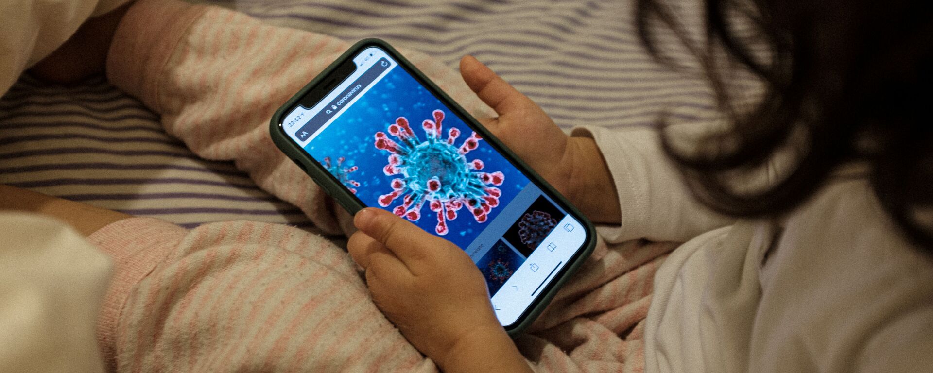 Маленькая девочка смотрит на иллюстрацию коронавируса на экране смартфона, Италия - Sputnik Таджикистан, 1920, 24.02.2021