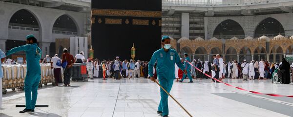 Уборщики в медицинских масках моют пол возле Каабы во внутреннем дворе мечети Масджид аль-Харам в Мекке - Sputnik Таджикистан