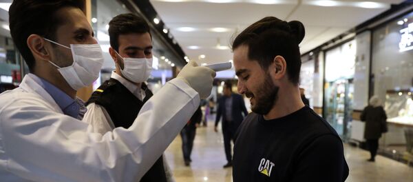 Медработники проверяют посетителя торгового центра в Тегеране на фоне вспышки коронавируса - Sputnik Тоҷикистон