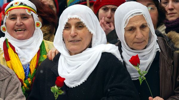 Турецкие курдские женщины с цветами во время демонстрации в Стамбуле в Международный женский день - Sputnik Тоҷикистон