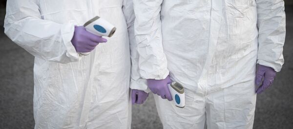 Медицинские работники в защитных костюмах с термометрами - Sputnik Тоҷикистон