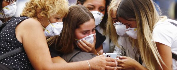 Путешественники в защитных масках смотрят на смартфон - Sputnik Таджикистан