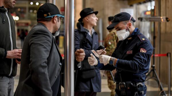 Полицейский в маске проверяет пассажиров, покидающих главный железнодорожный вокзал Милана - Sputnik Таджикистан