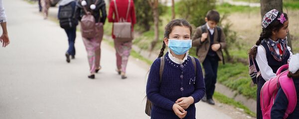 Школьница в медицинской маске на улице Душанбе - Sputnik Таджикистан